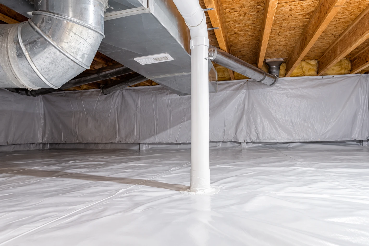 Crawl space floor and lower walls covered with a white vapor barrier around a central pipe and metal ductwork.